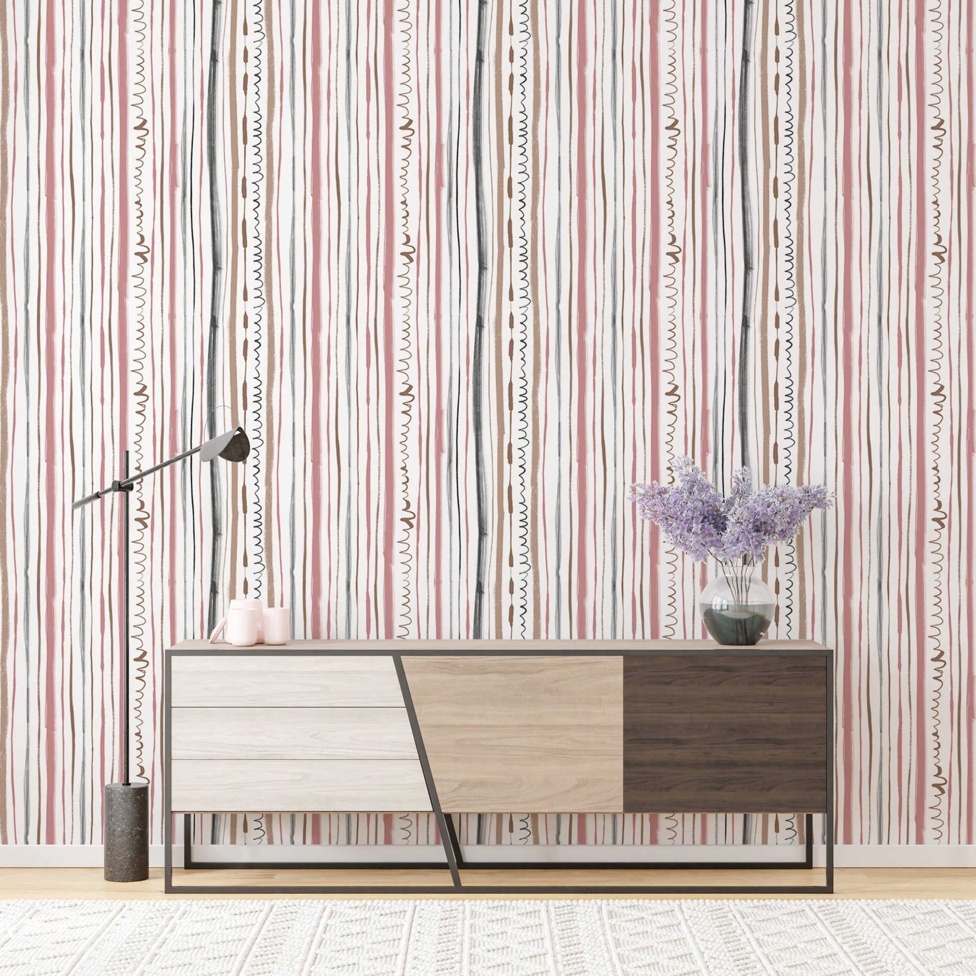 Vertical patterned wallpaper behind a modern wood console table