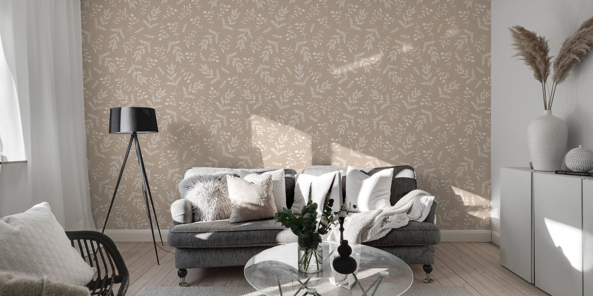 Neutral leaf wallpaper in a spacious living area with a grey sofa.