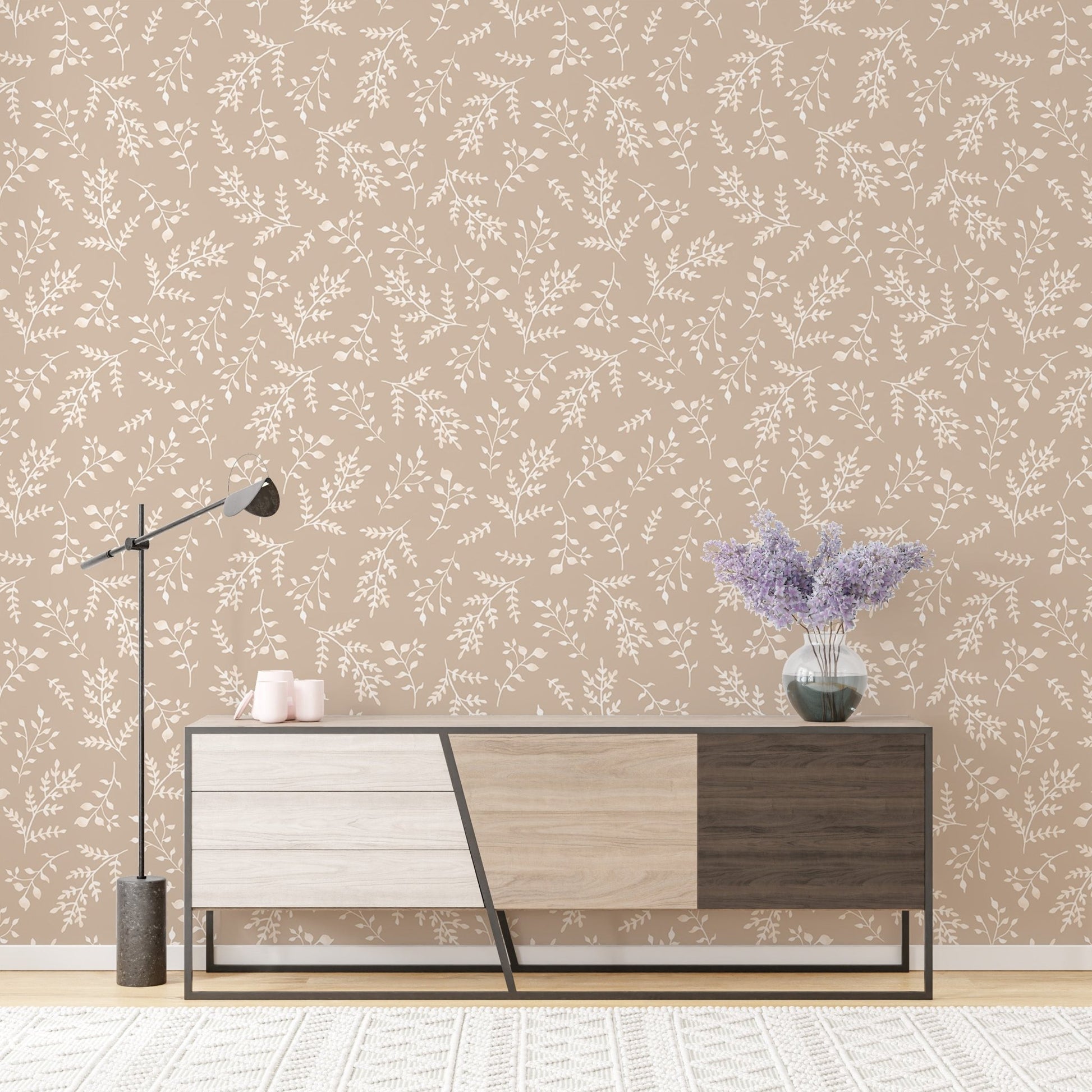 Neutral foliage wallpaper in a living room with a modern wooden sideboard.