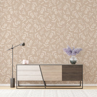 Neutral foliage wallpaper in a living room with a modern wooden sideboard.