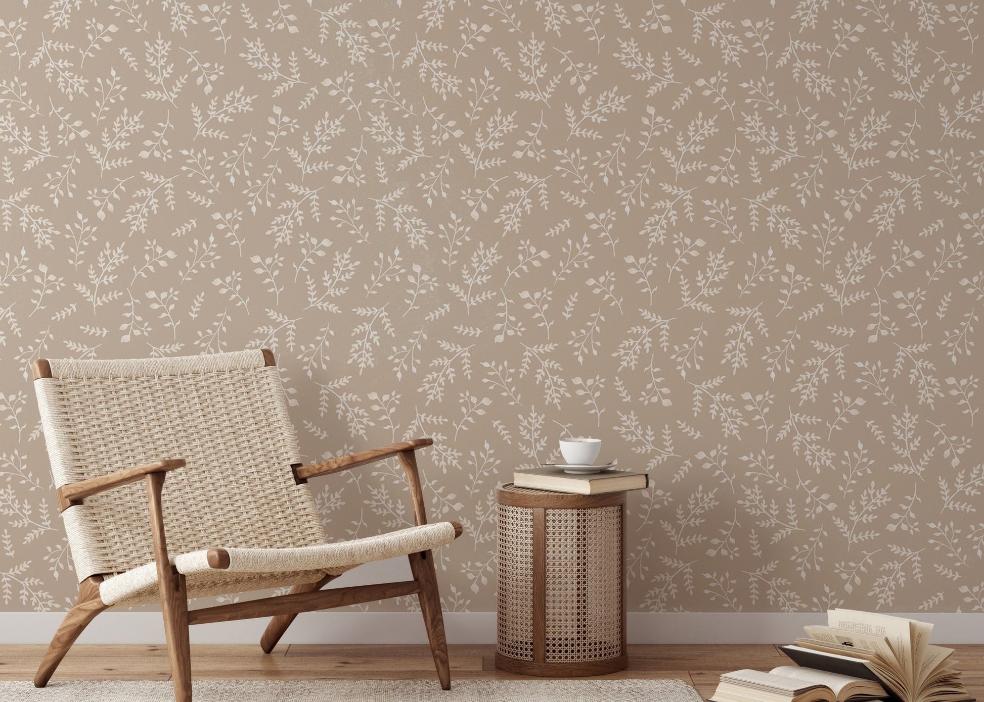 Pastel leaf wallpaper behind a lounge chair and wooden side table.