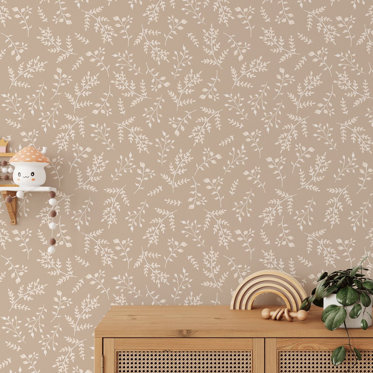 Cream leaf pattern wallpaper behind a wooden console table in a sunlit room.