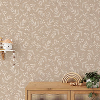 Cream leaf pattern wallpaper behind a wooden console table in a sunlit room.