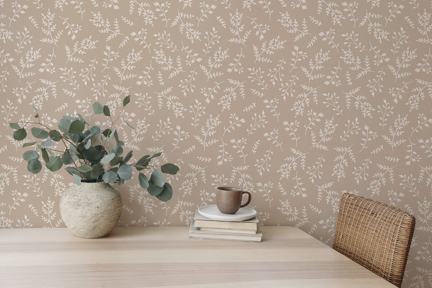 Botanical pattern wallpaper used as a backdrop for a minimalist desk setup.