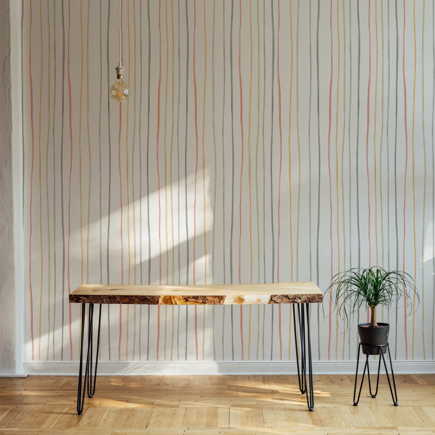 Vertical pastel lines wallpaper behind a wooden console table