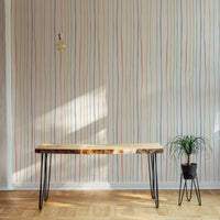 Vertical pastel lines wallpaper behind a wooden console table