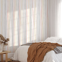 Pastel linear wallpaper in a bedroom with brown and white bedding
