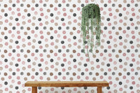 Home setup with a desk and grey and pink dot wallpaper covering.