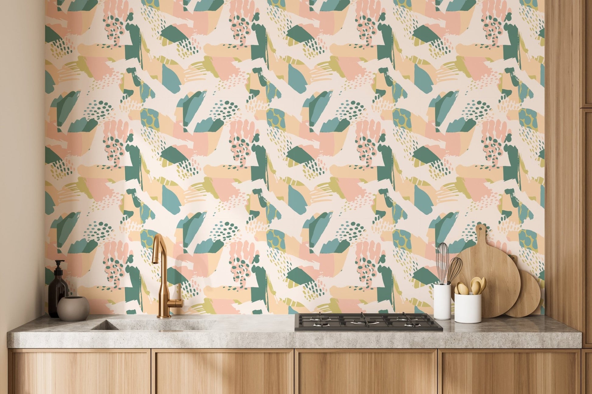 Pastel leaf and shapes wallpaper mural behind a modern kitchen counter.