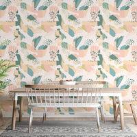 Abstract botanical pattern wallpaper in a dining area with a white table and mesh chair.