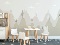 Nursery dining area wall mural showing pine trees and hills behind a white table and chairs.