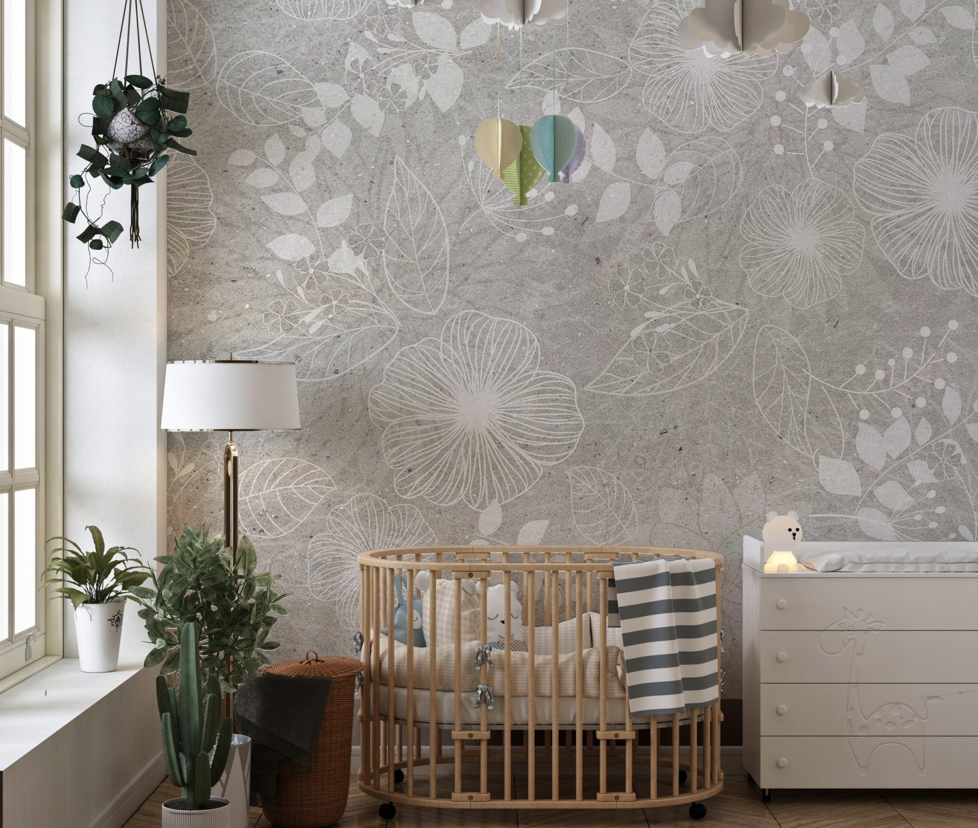 Nursery wall mural with white flower patterns and a wooden crib and green plants.