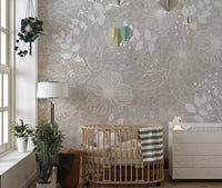 Nursery wall mural with white flower patterns and a wooden crib and green plants.