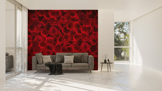 Floral bouquet wallpaper mural behind a grey sofa in a bright, sunlit living area.