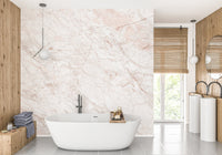 Luxury bathroom design with pink stone effect wall mural and natural light.