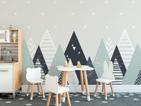 Nordic mountain wall mural in a kids play area with white table and chairs.