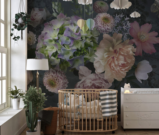 Floral garden wall mural in a nursery with a wooden crib and indoor plants.