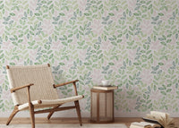 Minimalist chair next to a wallpaper featuring soft pastel leaf illustrations.
