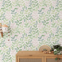 Wooden cabinet and indoor plants positioned in front of a botanical leaves wallpaper.