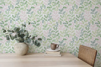 Wallpaper with a repeat leaf design behind a light wood dining table and vase.