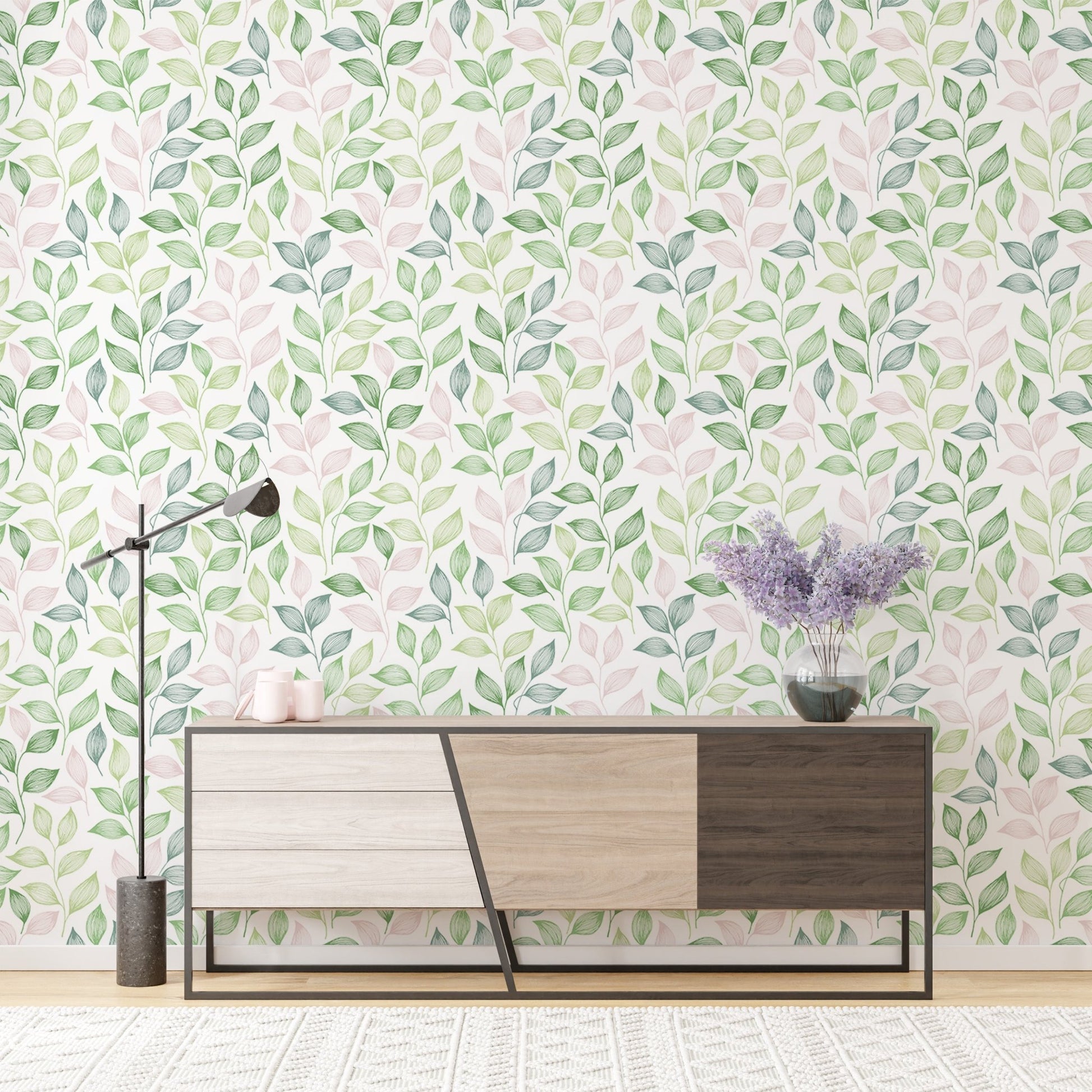 Wallpaper with pink and green leaf patterns behind a modern wooden sideboard.