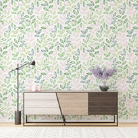 Wallpaper with pink and green leaf patterns behind a modern wooden sideboard.