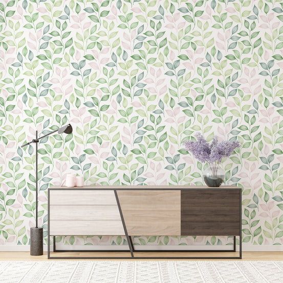 Wallpaper with pink and green leaf patterns behind a modern wooden sideboard.