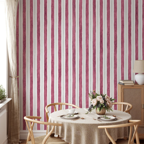Vertical pink stripes wallpaper behind a round dining table and chairs.