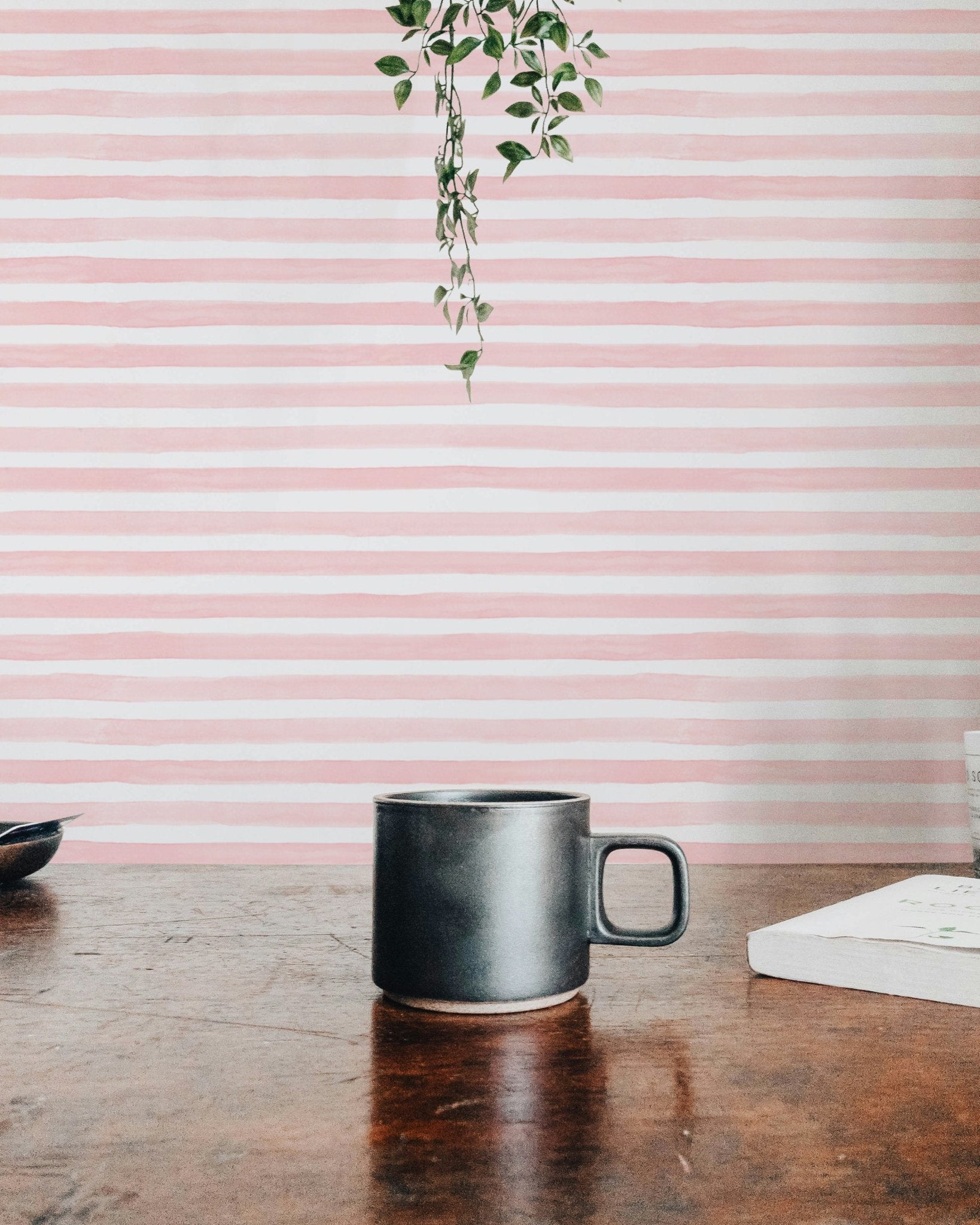 Pink Color Abstract Stripe Watercolor Wallpaper behind a wooden table.