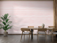 Horizontal pink stripe wallpaper in a dining room with a large green plant.