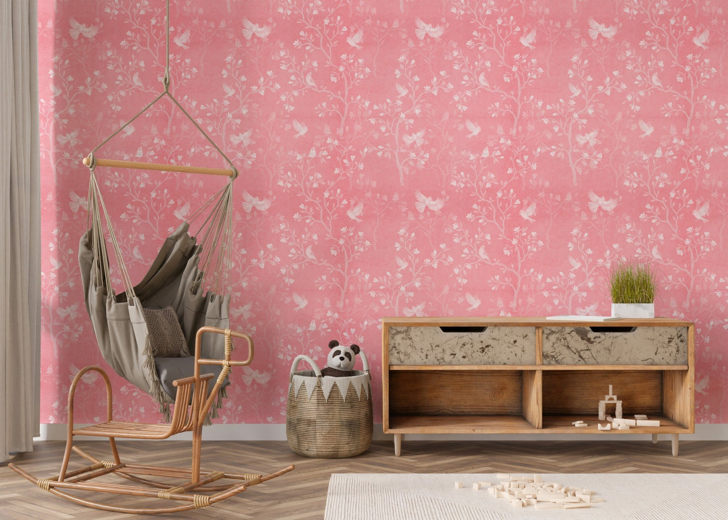 Modern nursery area featuring a pink floral wallpaper and hanging chair.