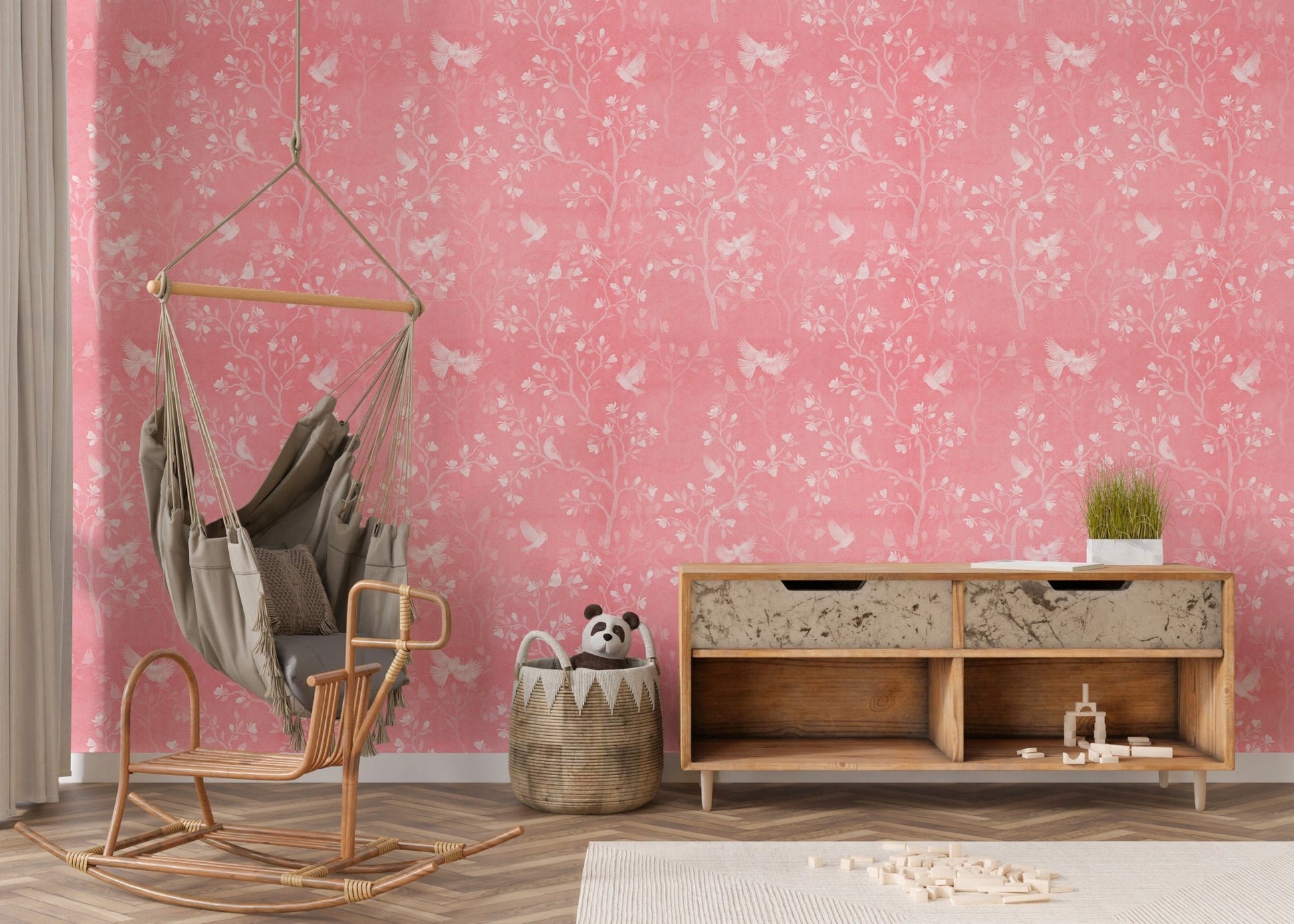 Modern nursery area featuring a pink floral wallpaper and hanging chair.