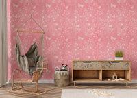Modern nursery area featuring a pink floral wallpaper and hanging chair.