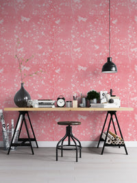 Workspace featuring pink chinoiserie wallpaper and a black industrial desk.