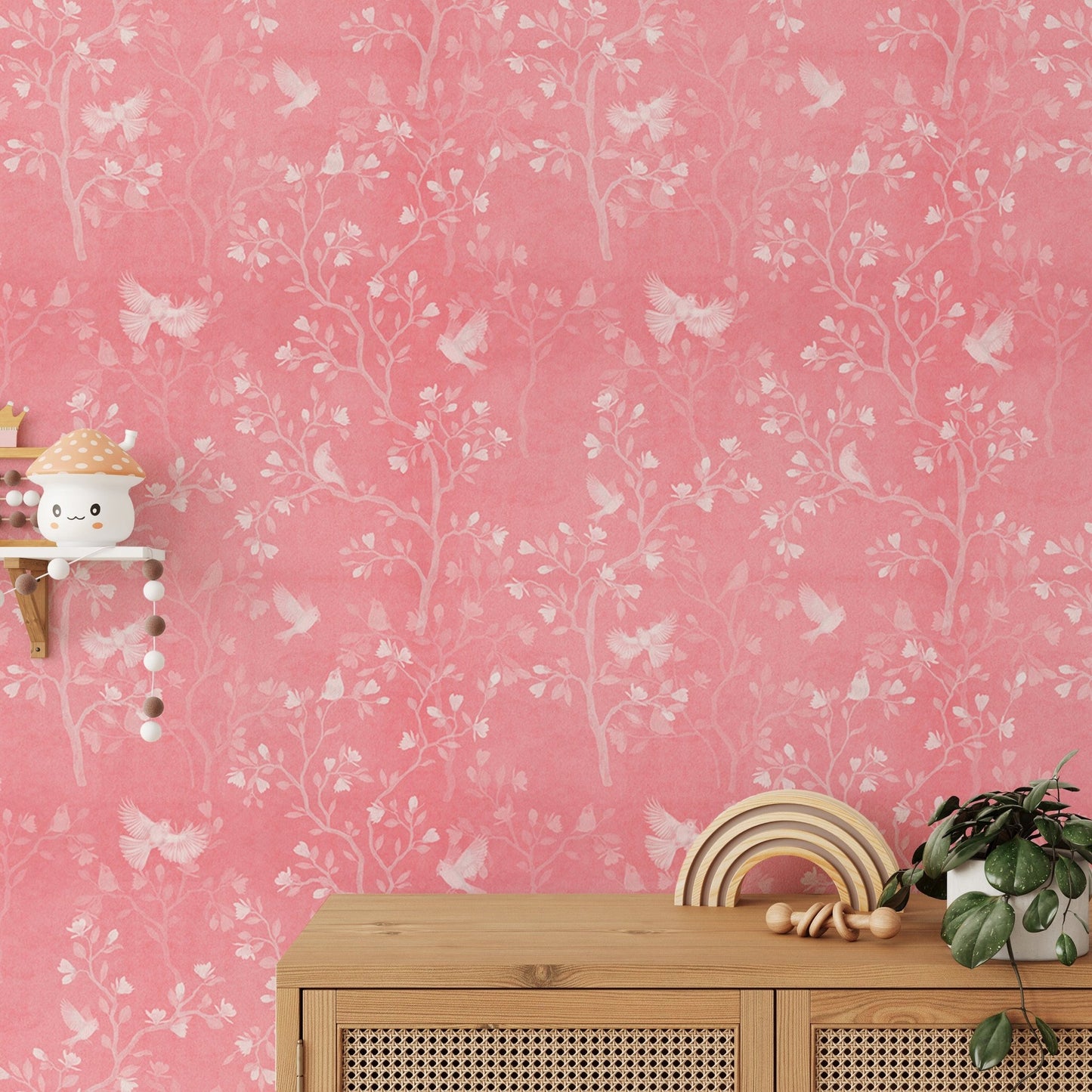 Magnolia tree and birds wallpaper behind a wooden console table with decor.