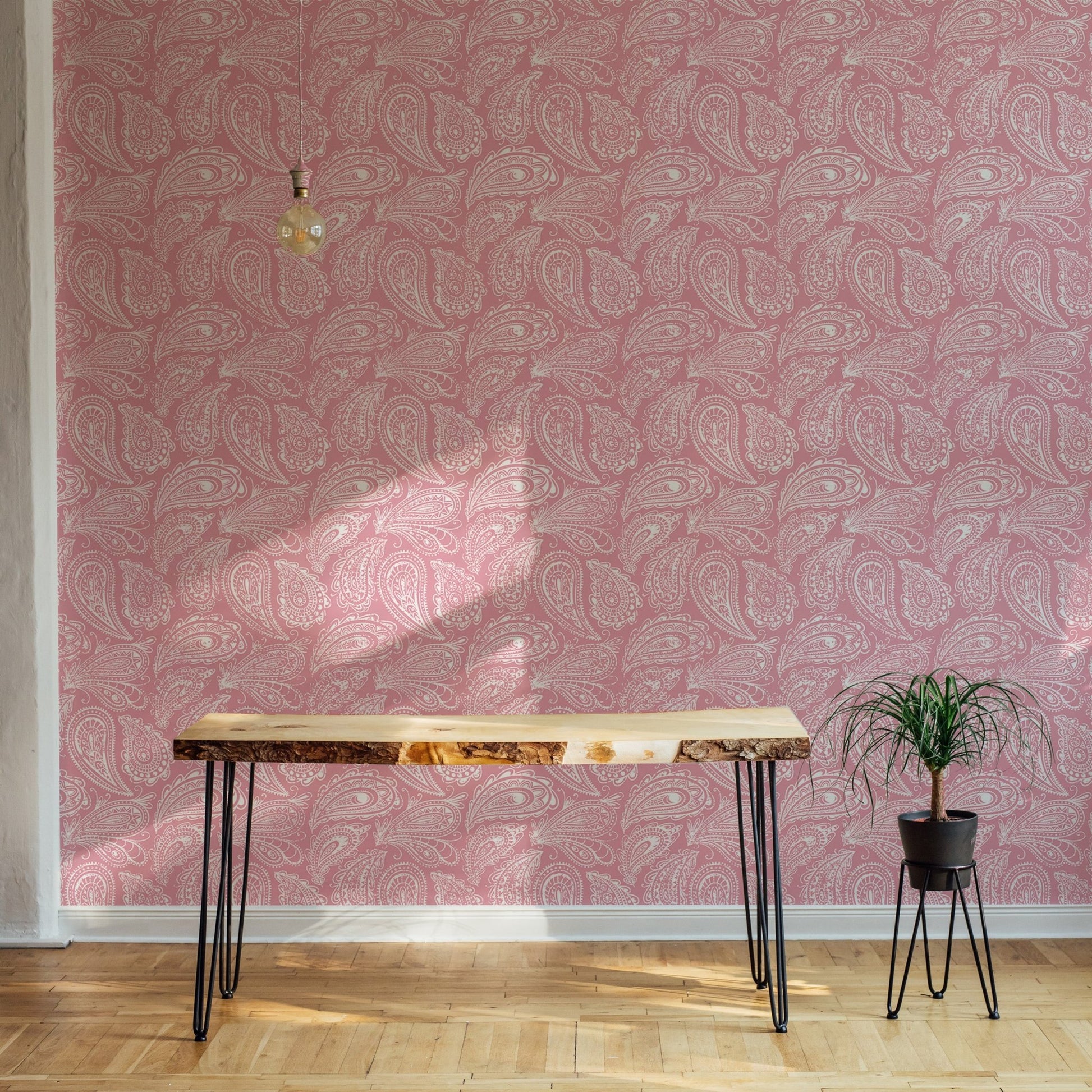 Pink paisley ornament wallpaper used in a minimalist room with a wood desk.