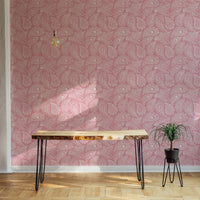 Pink paisley ornament wallpaper used in a minimalist room with a wood desk.
