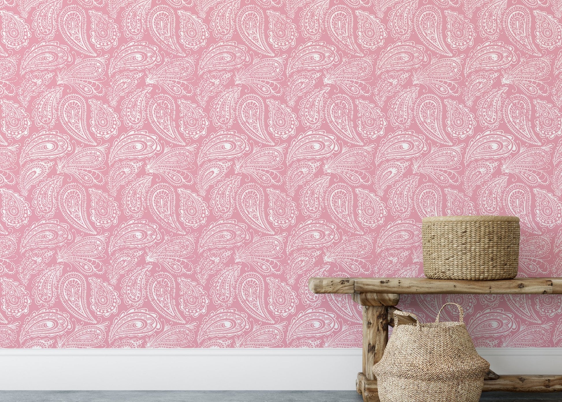 Pink paisley wallpaper on a large wall behind a wooden bench and basket.