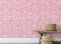 Pink paisley wallpaper on a large wall behind a wooden bench and basket.