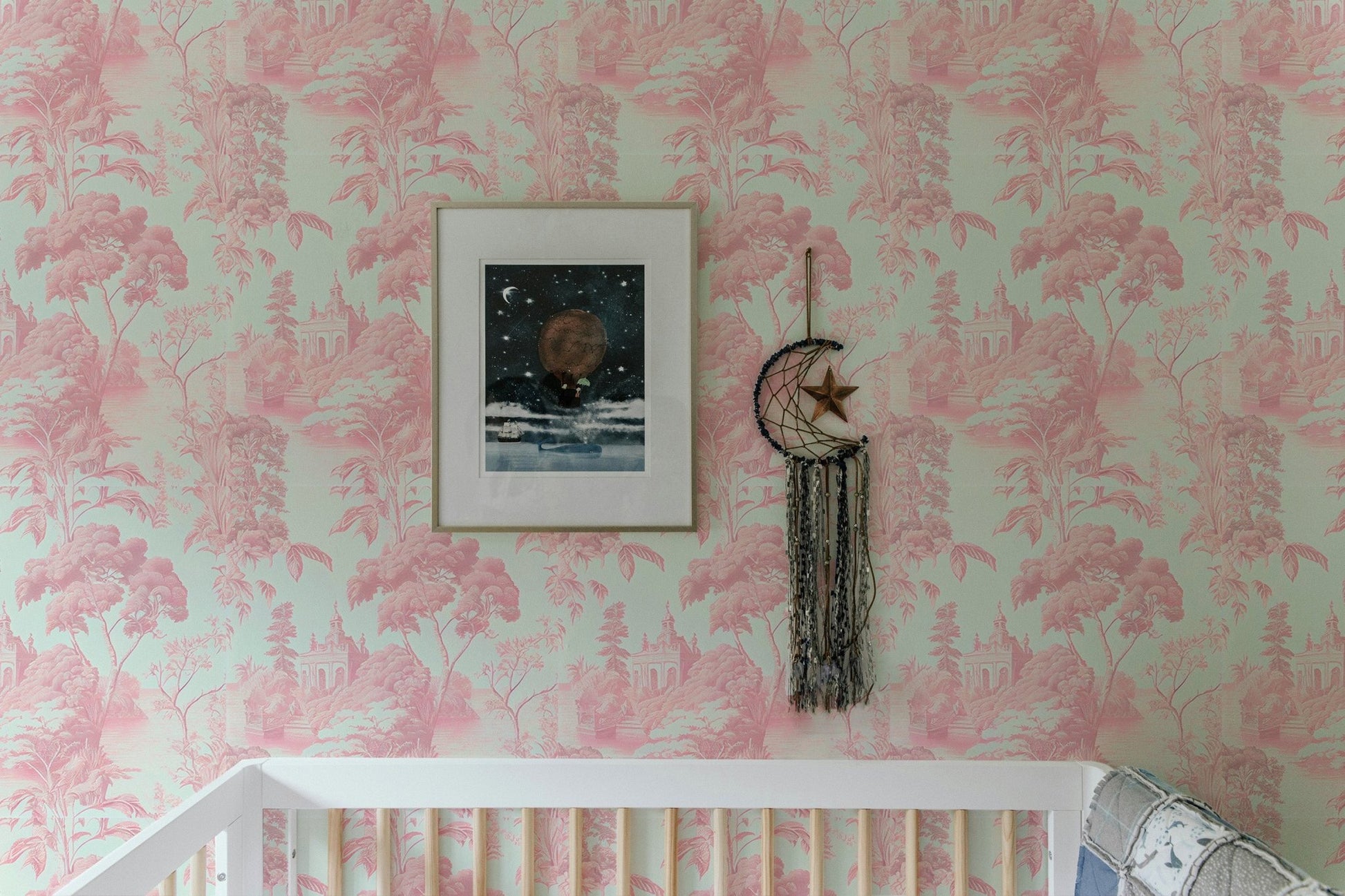 Toile tropical wallpaper in nursery room above white crib