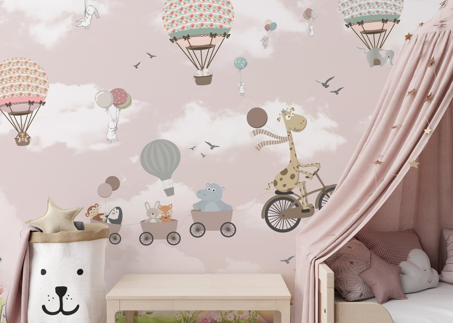 Kids room wall mural featuring a giraffe on a bicycle and pink balloons near a canopy bed.