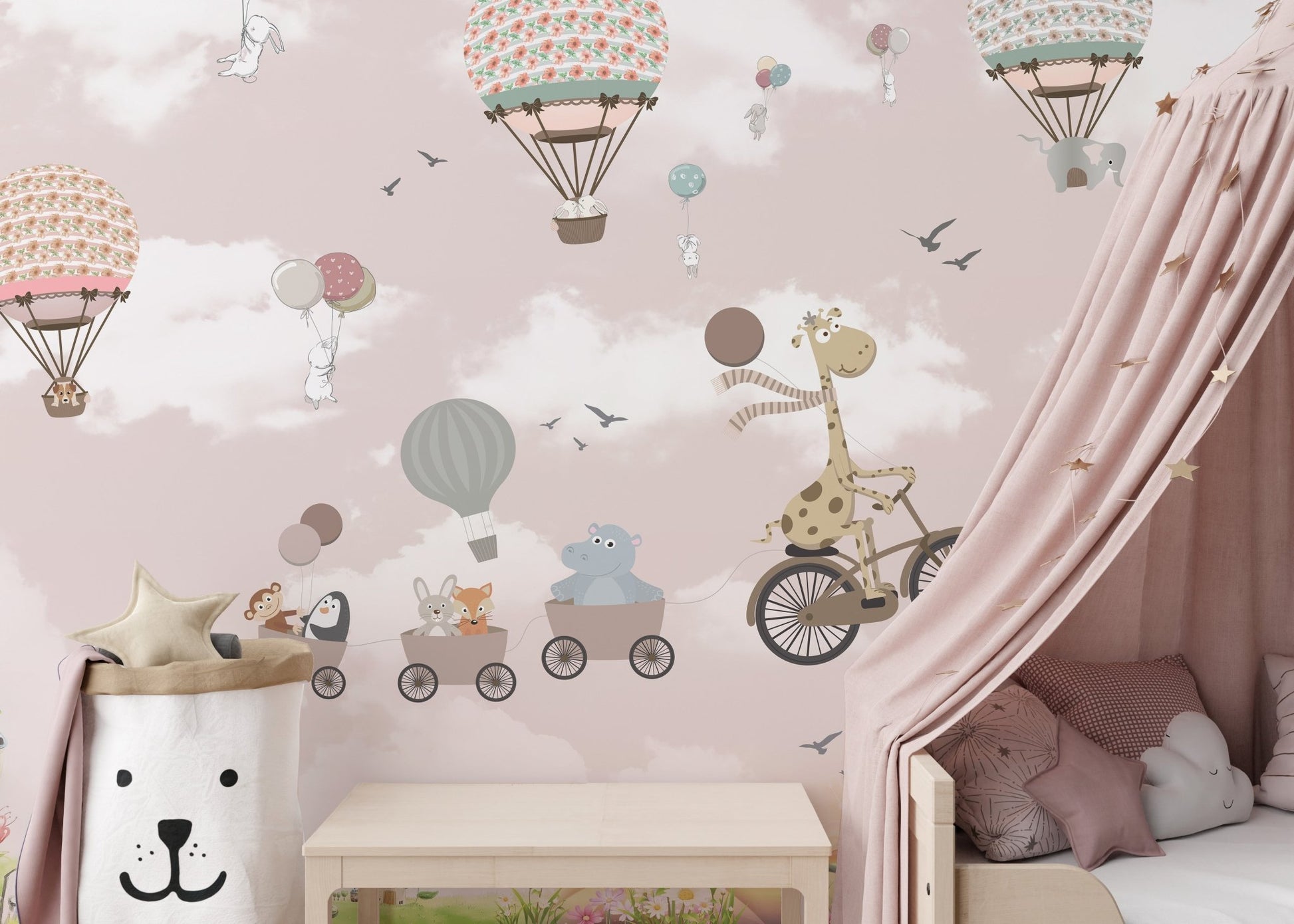 Kids room wall mural featuring a giraffe on a bicycle and pink balloons near a canopy bed.