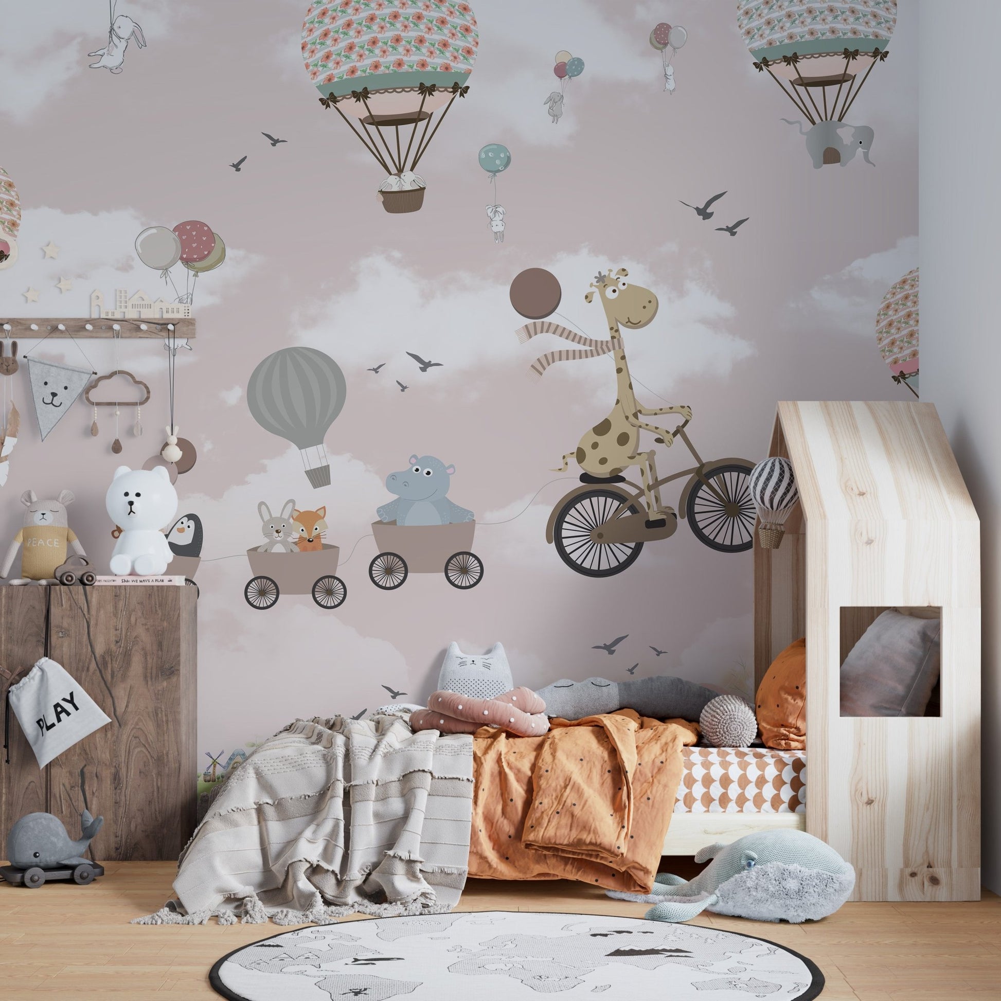 Pink Hot Air Balloon Animals Bicycle Wall Mural behind a wooden house-shaped bed.