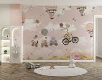 Large scale wall mural showing animals in hot air balloons and a giraffe on a cycle in nursery.