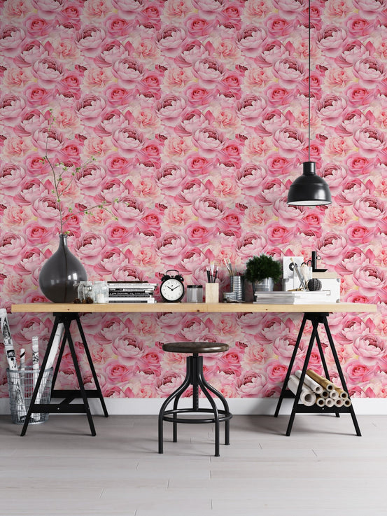 Pink peonies roses wallpaper on office wall with wooden desk and black trestle legs.