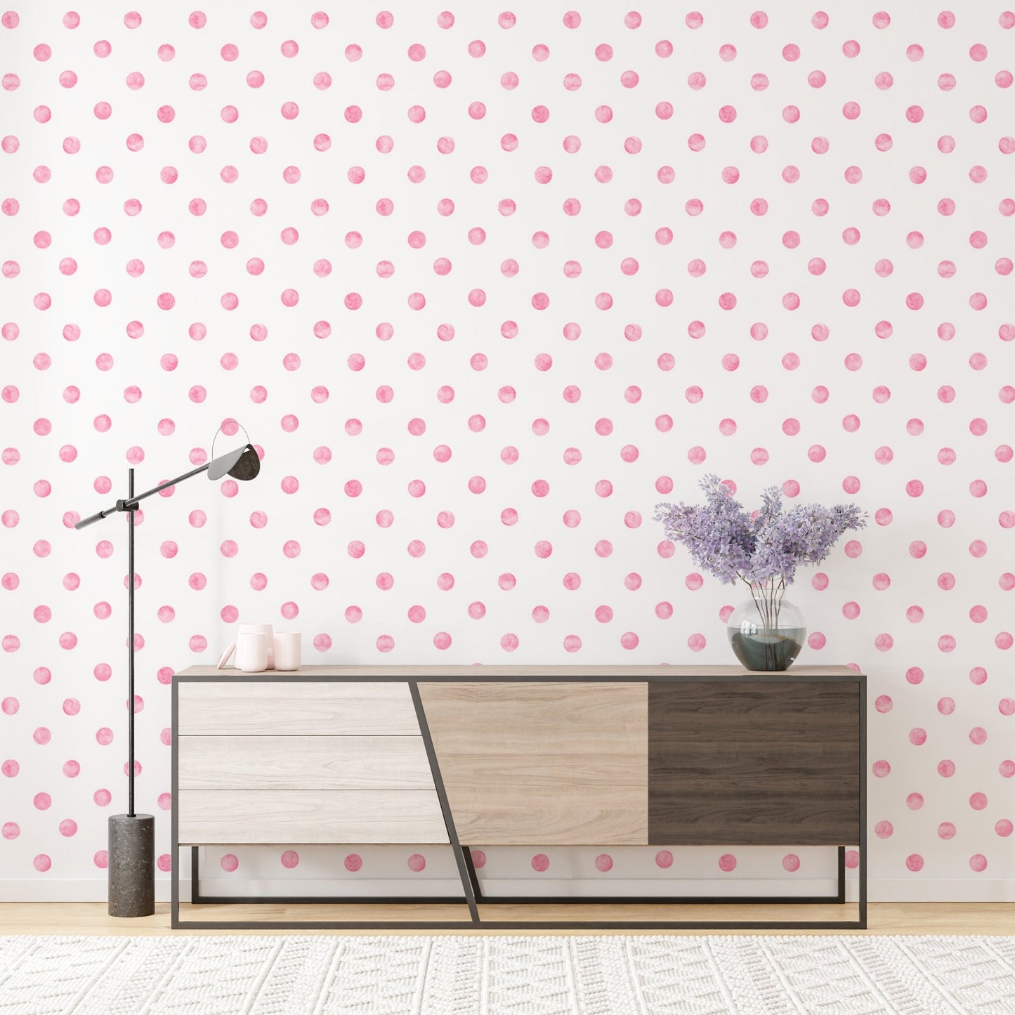 Pink watercolor seamless pattern polka dots wallpaper behind a modern wood sideboard.
