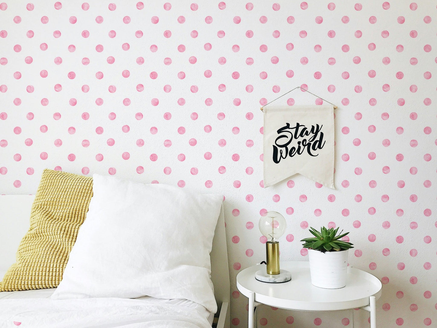 Bedroom wallpaper featuring pink spots behind a white bed and side table.