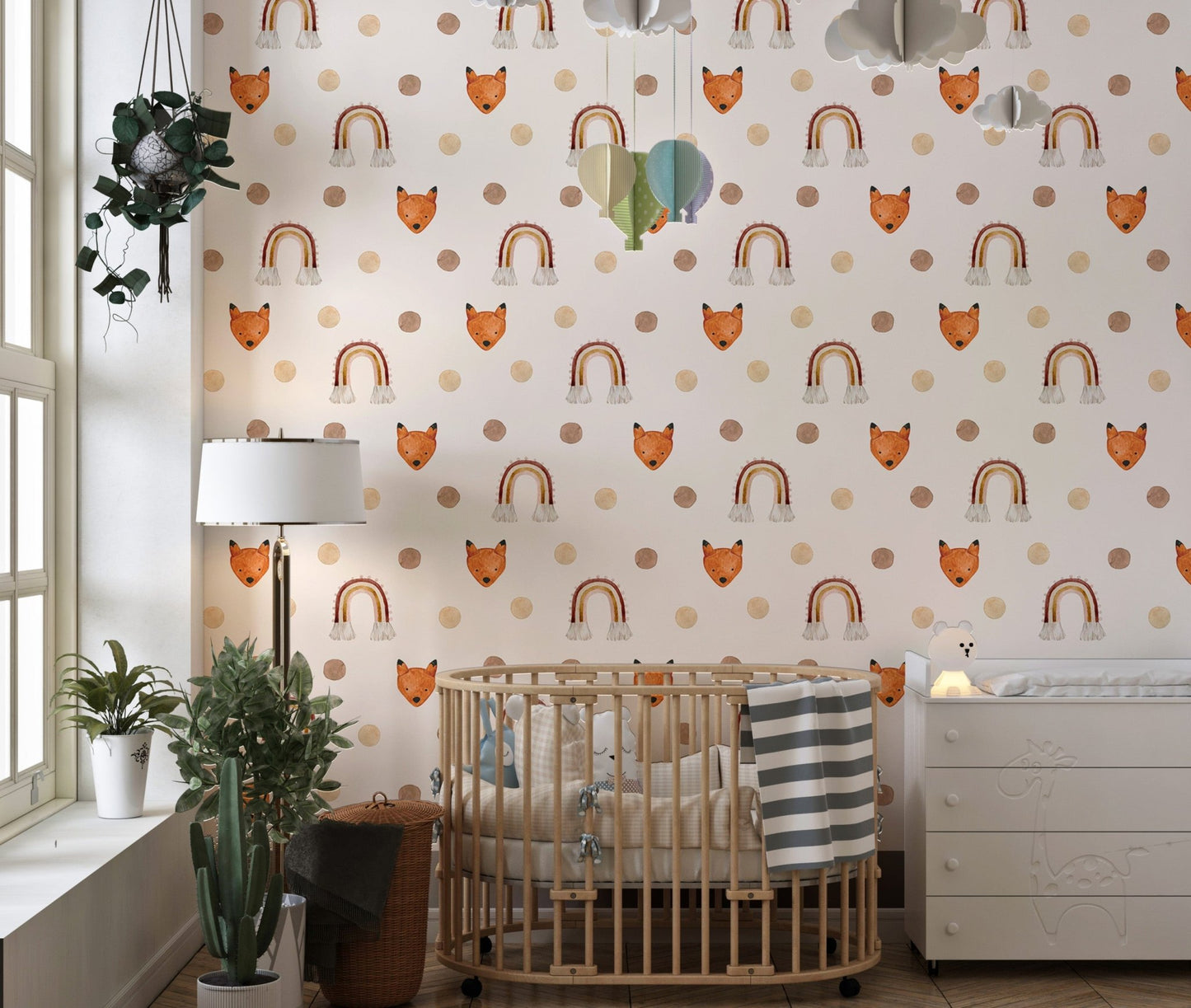 Nursery wallpaper featuring orange foxes and rainbows next to a wooden crib.