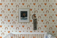 Detailed view of rainbow and fox wallpaper in a nursery with a white cot.