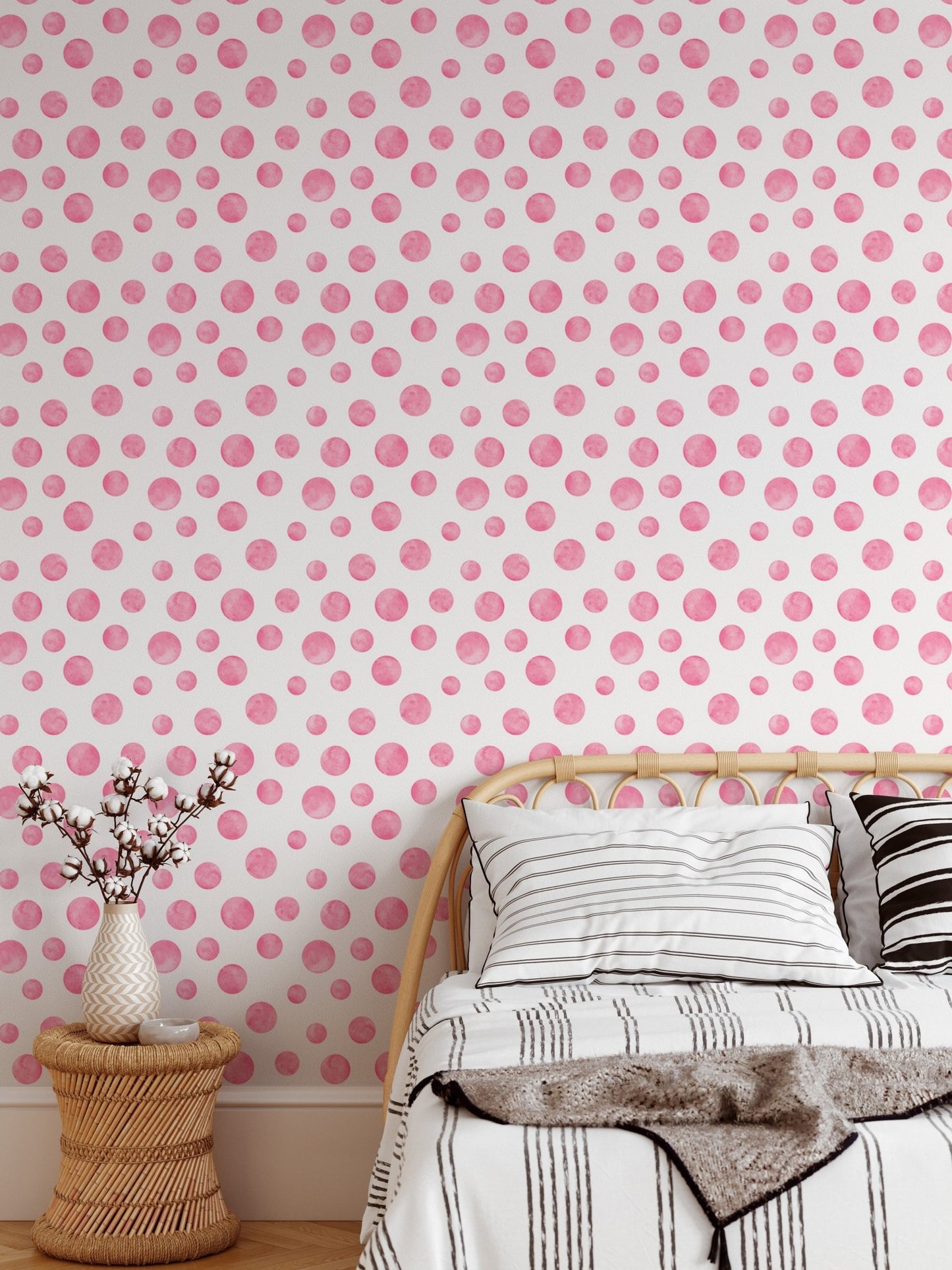 Watercolor dots wallpaper behind a wooden bed frame with neutral bedding.
